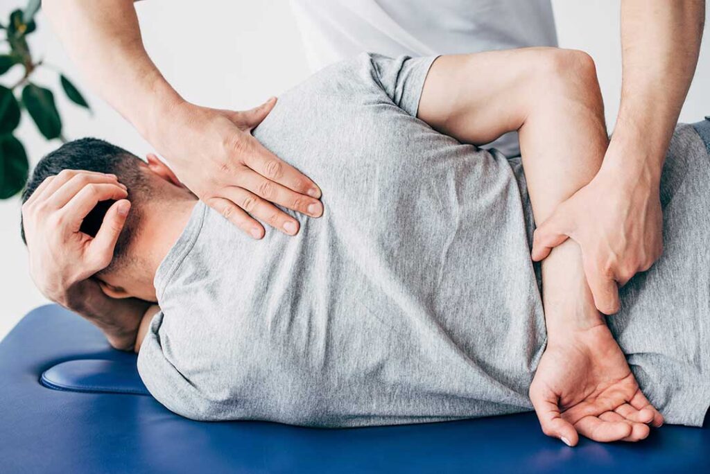 Older adult doing gentle stretching exercises on a yoga mat in a sunlit living room.